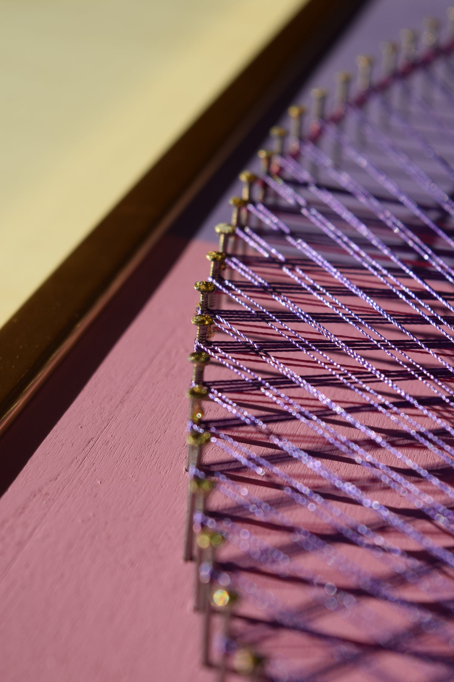 Close-up of Butterfly Yin Yang string art showing intricate nail work and violet thread detail.