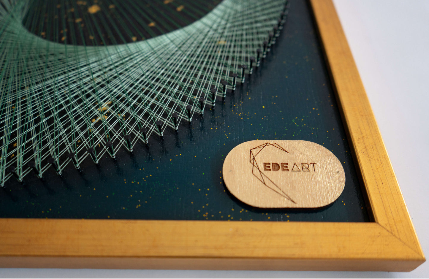 Detailed shot of EDEART logo and golden frame of the Green Galaxy Yin Yang painting, showcasing luxury and craftsmanship.