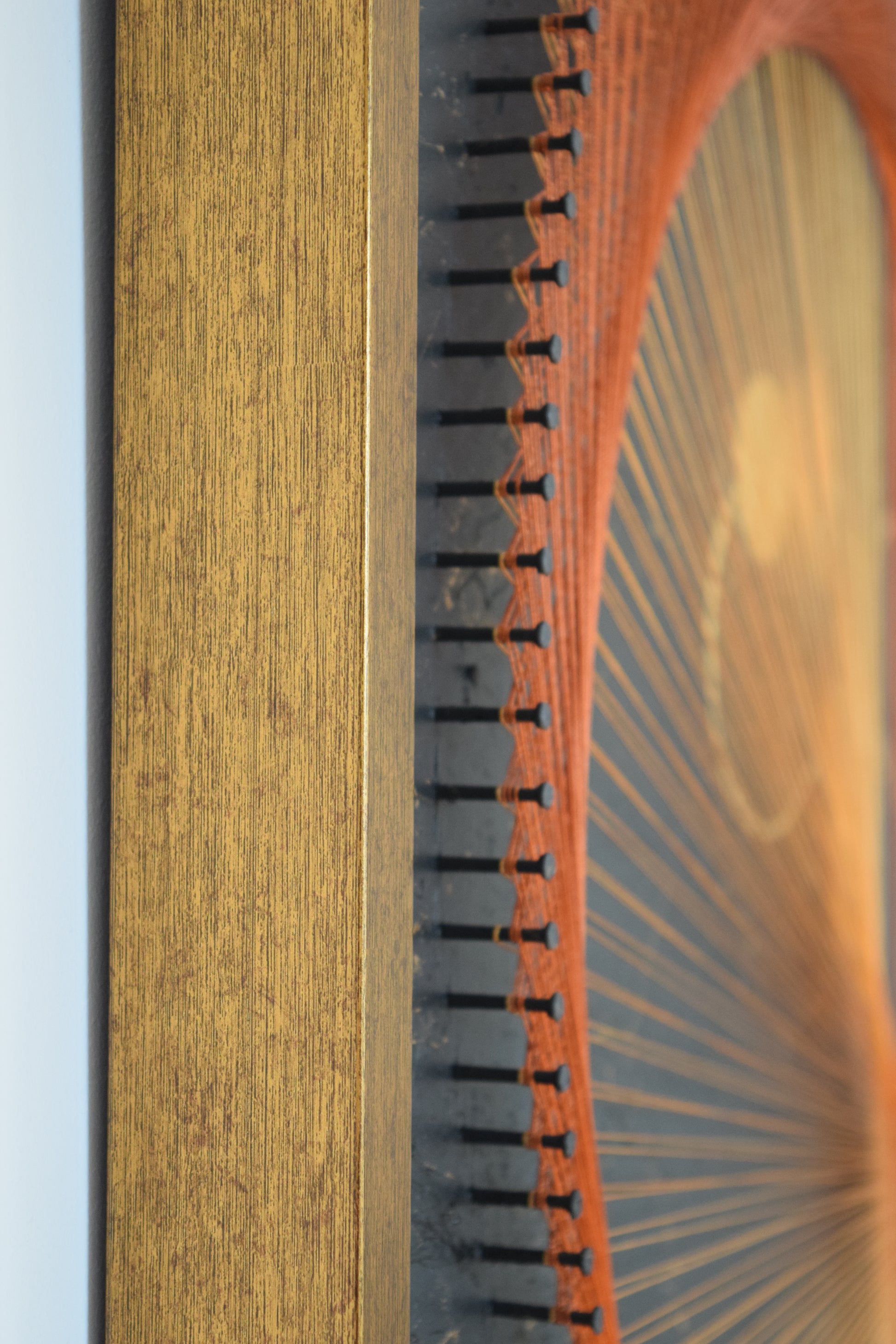 Detailed view of the rust-colored frame surrounding the Infinity Yin Yang artwork – warm tone complementing gold and marble.