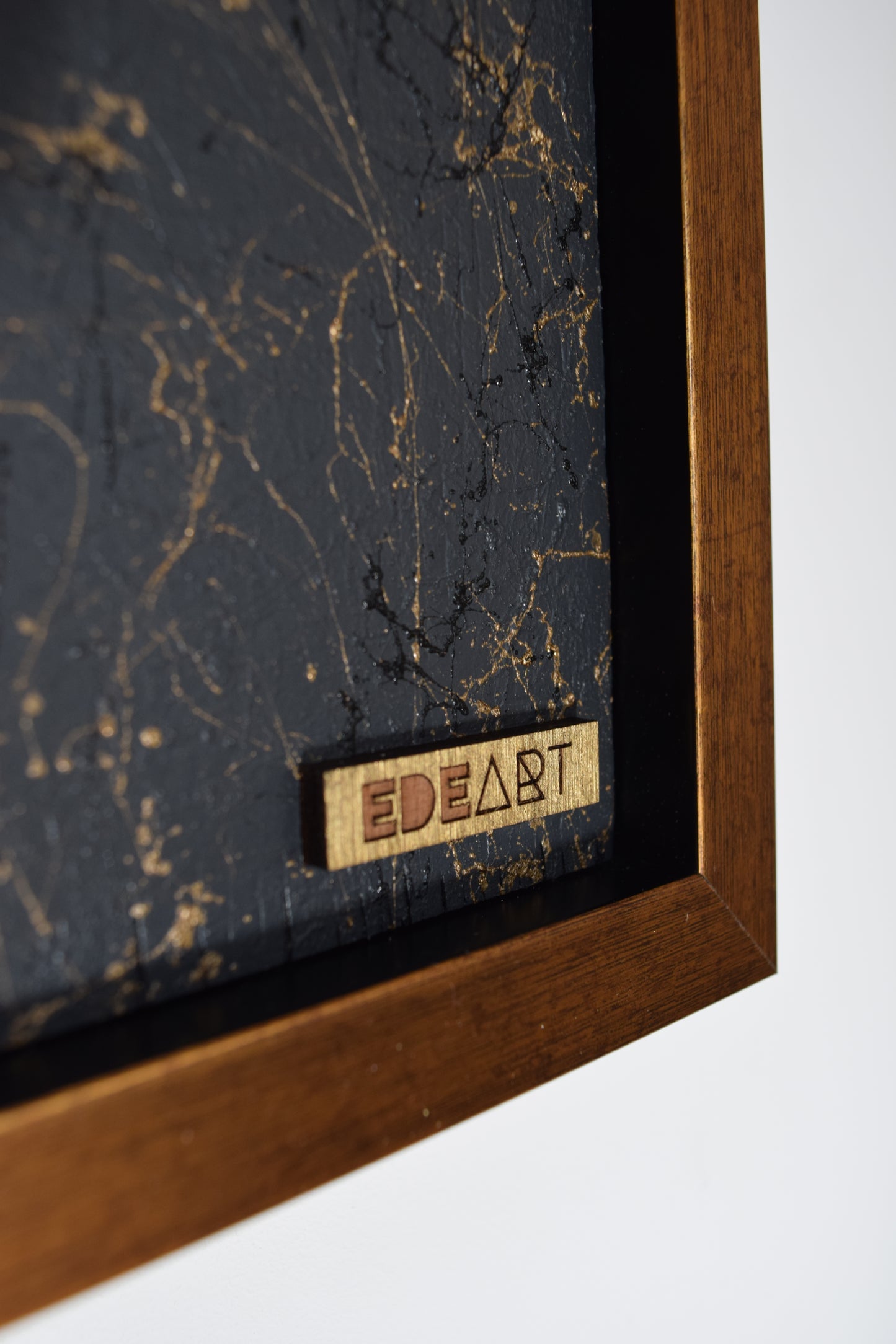 Zoomed-in image of EDEART gold logo in the right corner – signature mark of authenticity and premium craftsmanship.