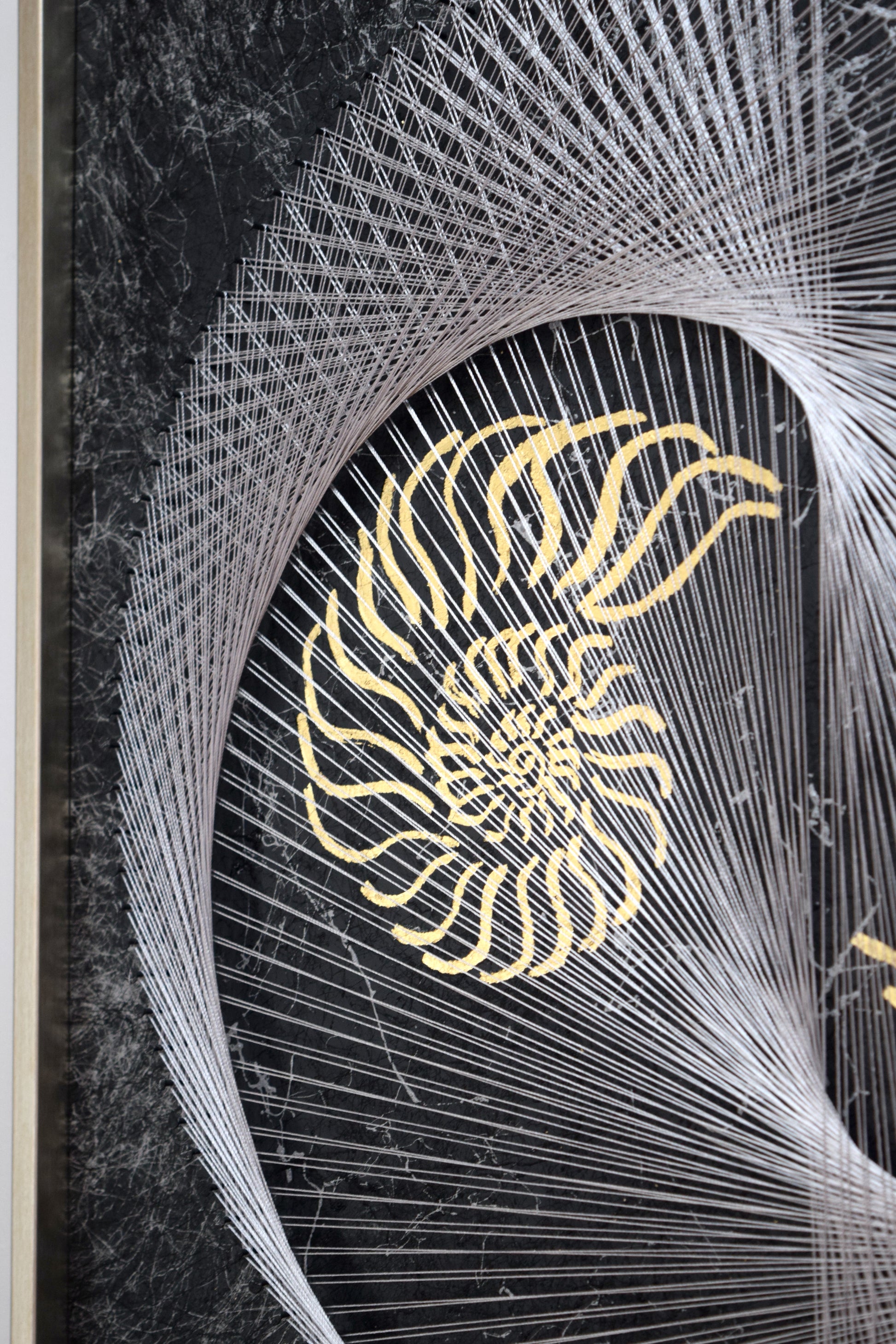 Close-up on strong thread work and half yin yang with abstract gold nautilus symbol, representing flow and depth.