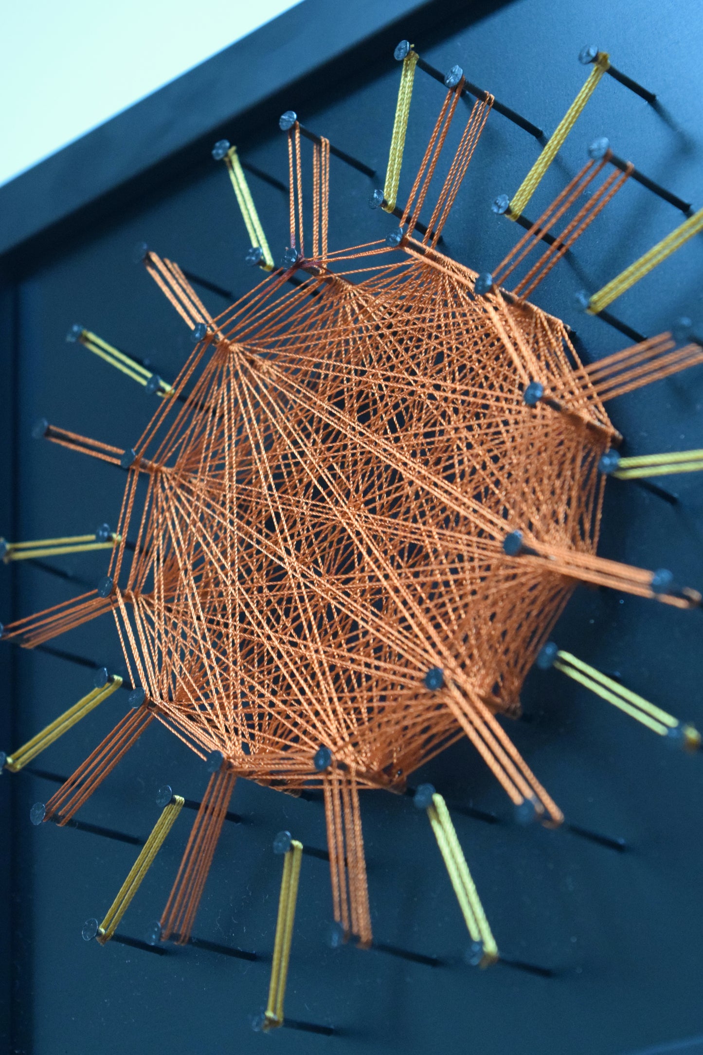 Close-up of copper thread sun mandala – vibrant and empowering wall art