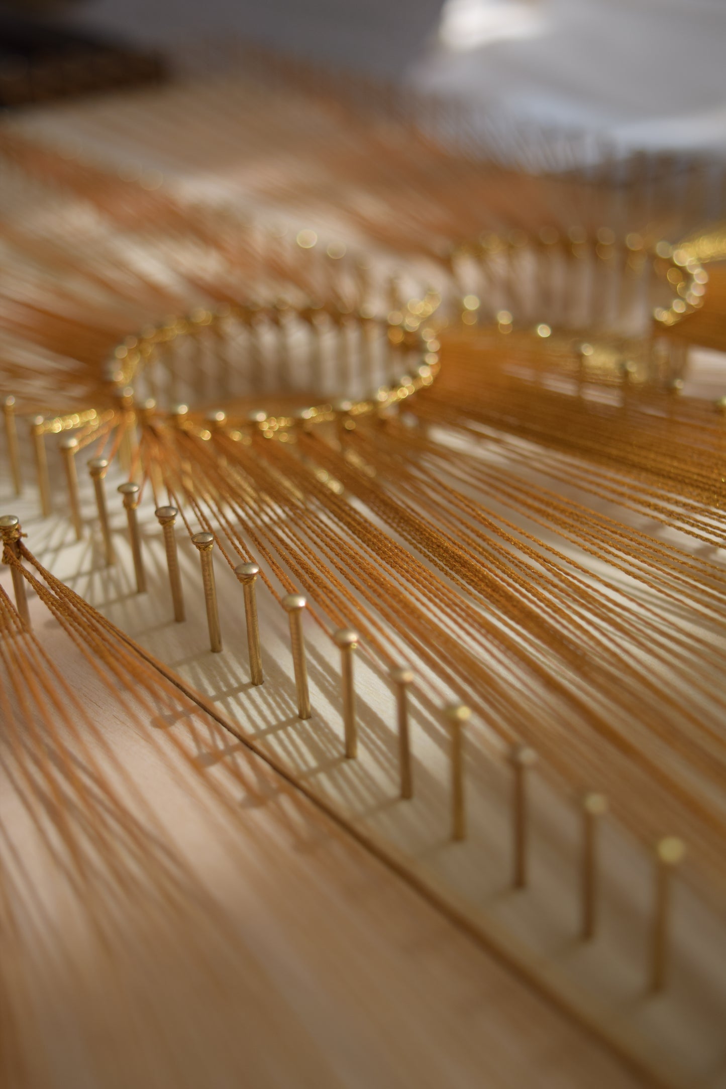 Macro photo of gold nails in Sun Phases artwork – precise hand-nailed string art with luxurious metallic accents.