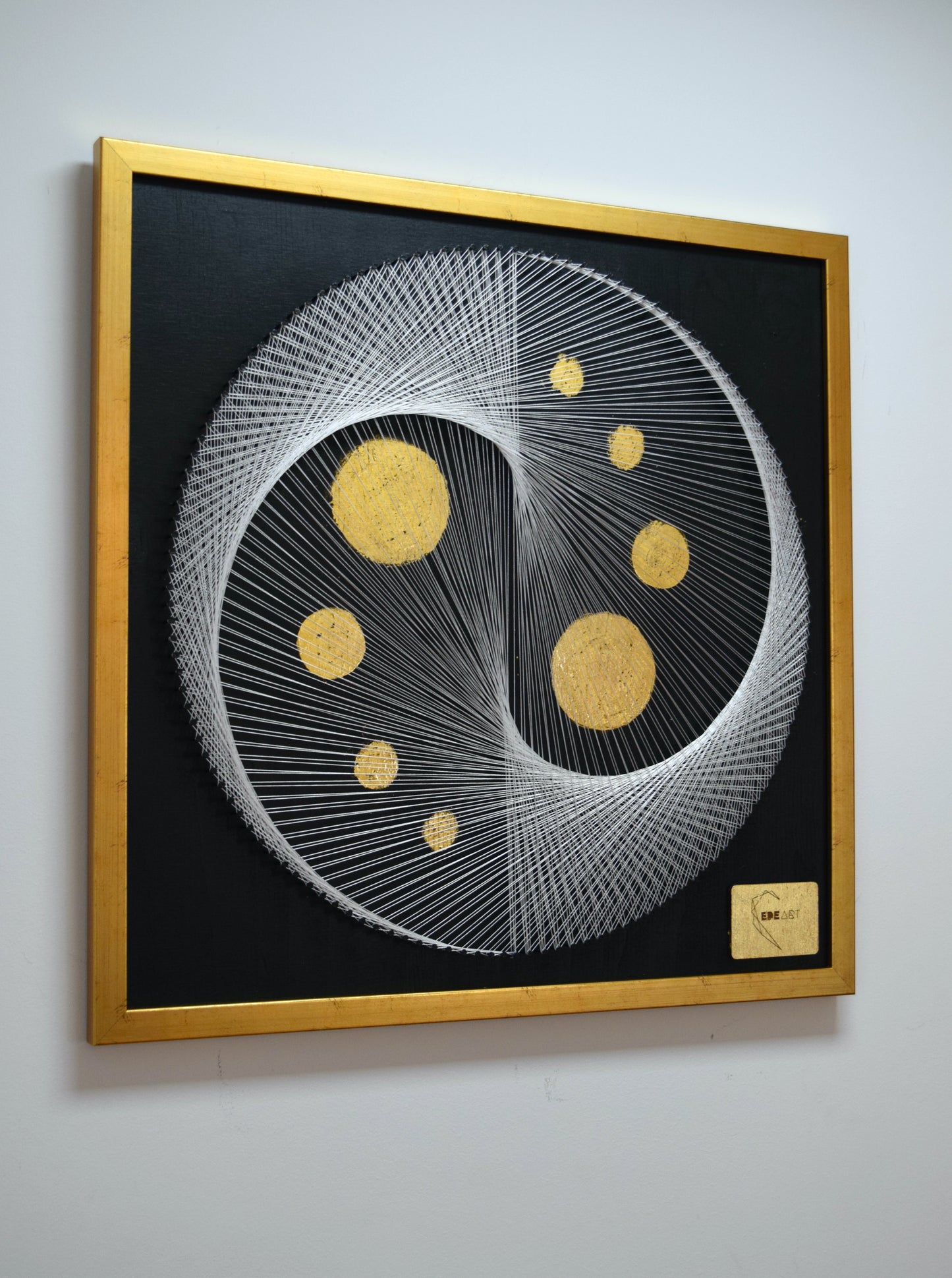 Left angle photo of White Yin Yang painting showing gold leaf moons and fine string geometry with premium gold frame.