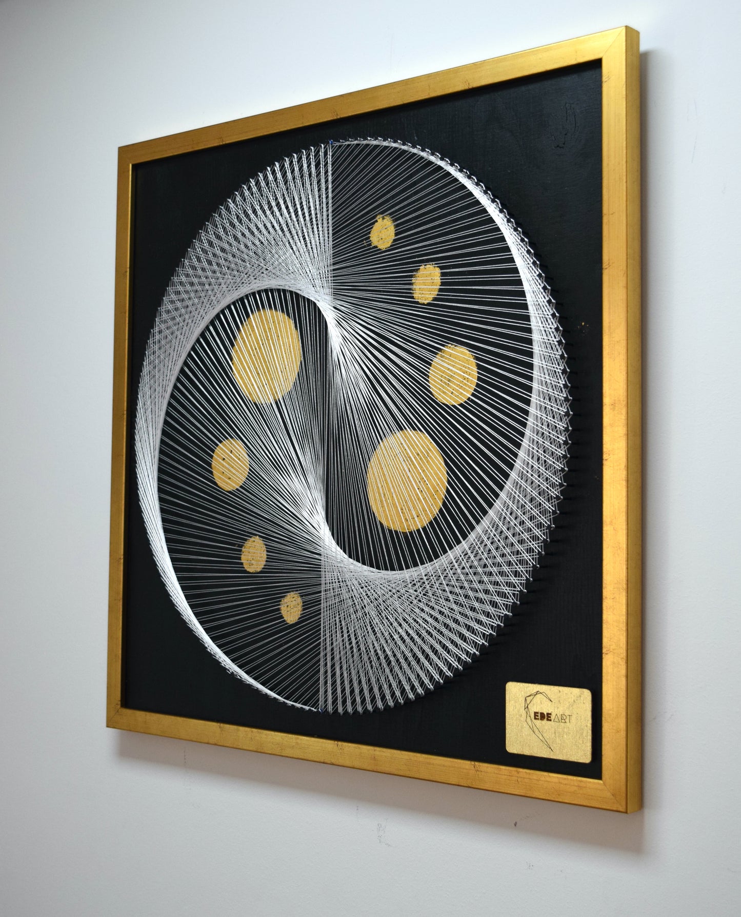 Right angle view of White Yin Yang painting with 22K gold full moons and elegant gold frame.