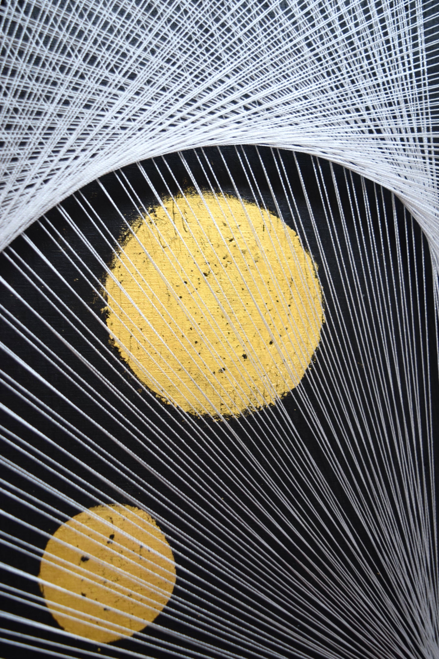 Detail of 22K gold full moon with interwoven thread in White Yin Yang string art – elegant sacred geometry.