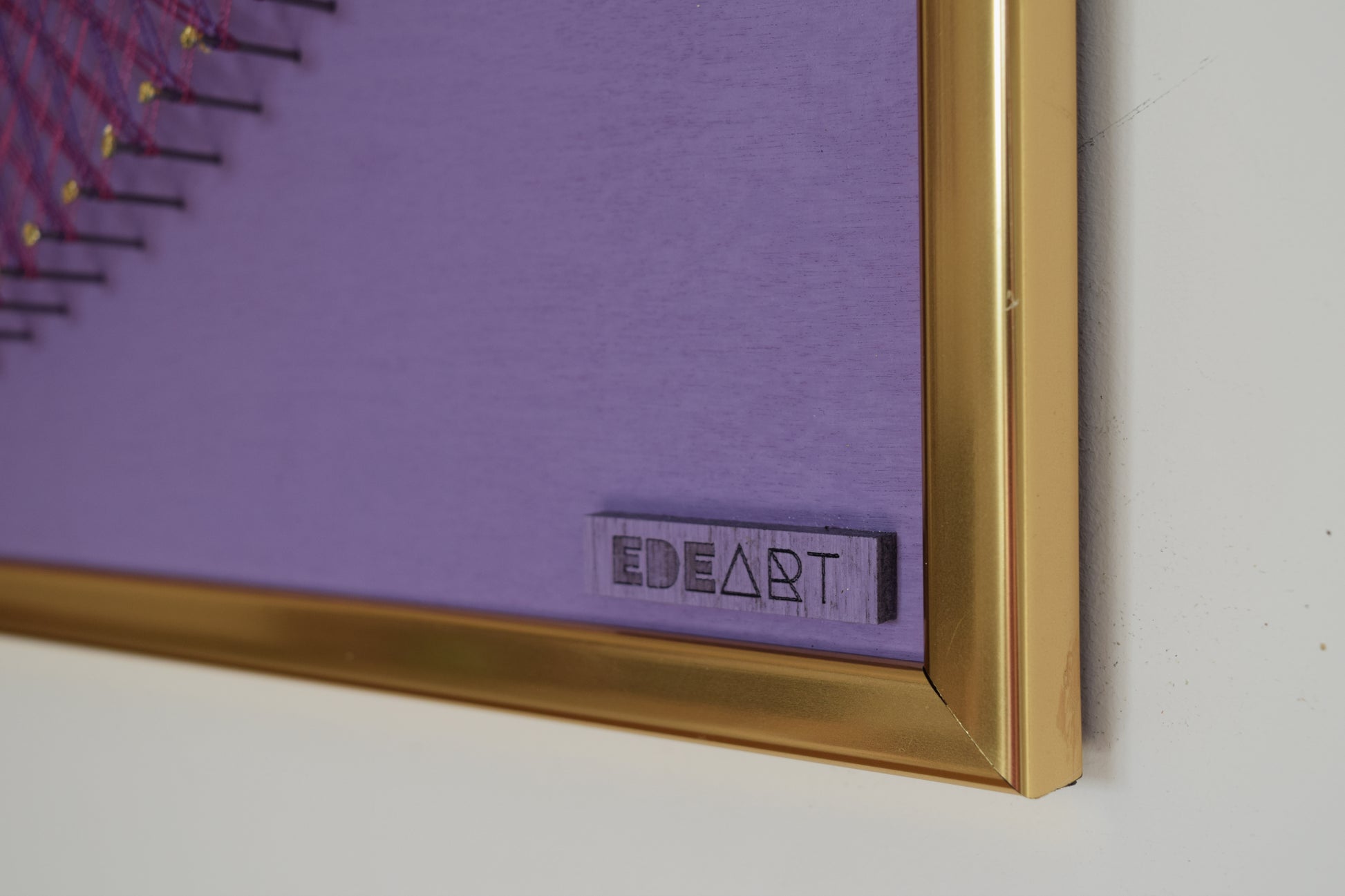 Close-up of EDEART logo on string art artwork, showcasing fine branding and artistic craftsmanship.