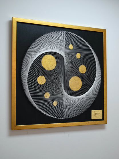 Left angle photo of White Yin Yang painting showing gold leaf moons and fine string geometry with premium gold frame.